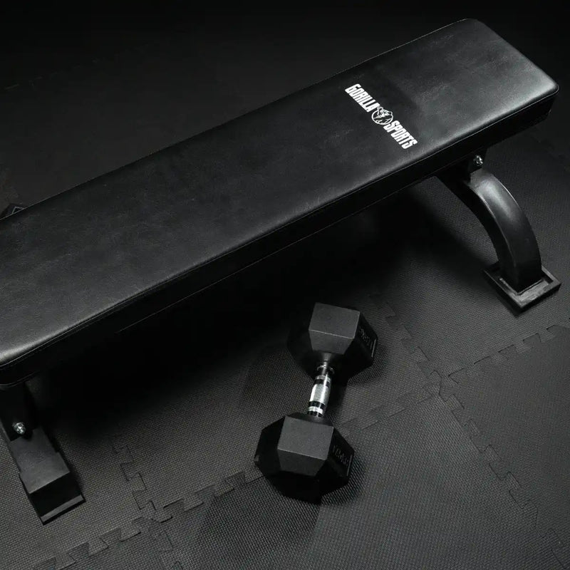 banc plat et haltère hexagonal sur tapis de protection de sol